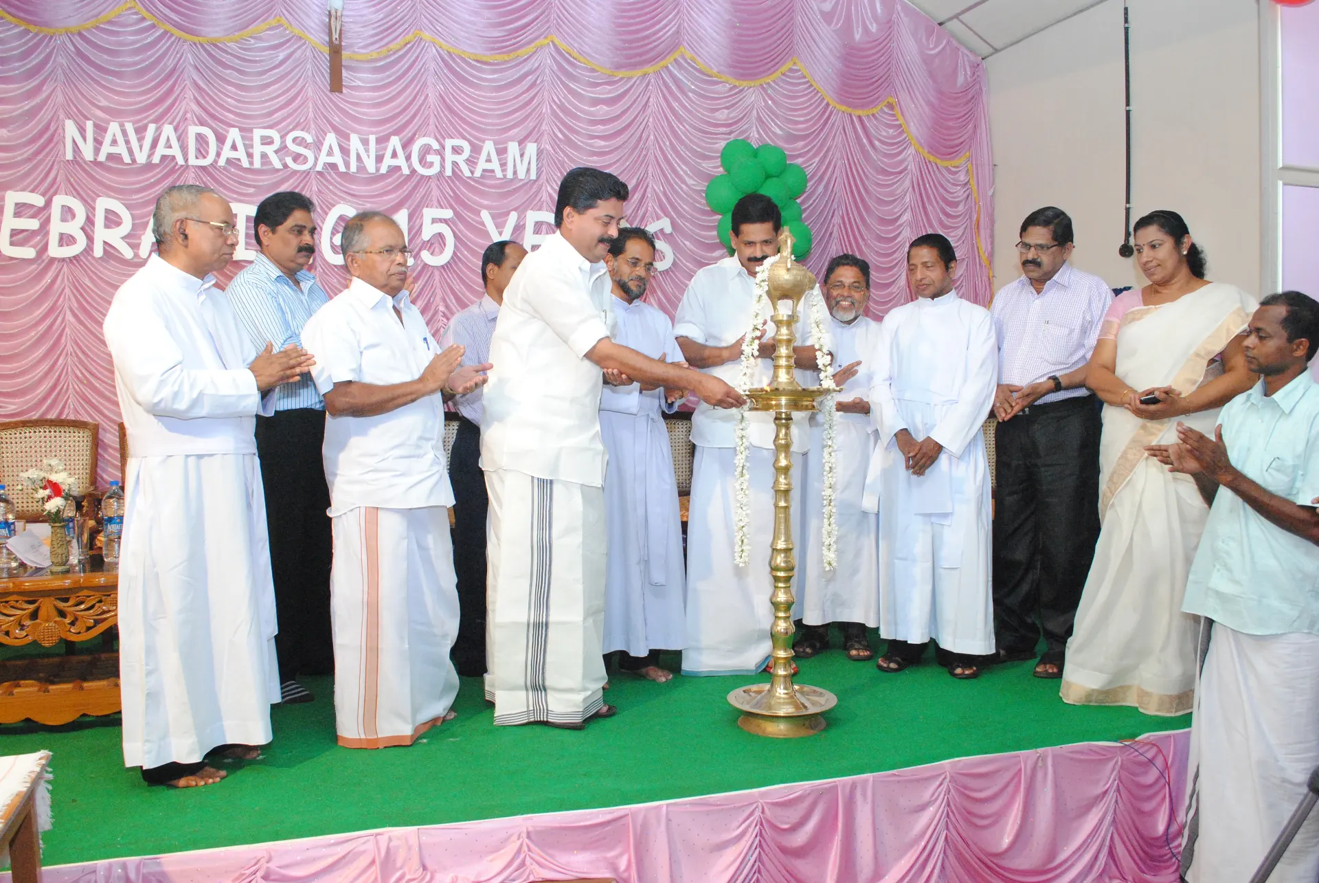 Guests lighting a ceremonial lamp at Navadarsanagram’s 15th-year celebration
